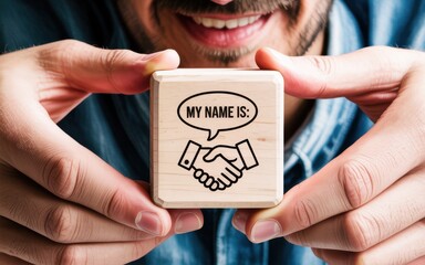 A smiling businessman holds a wooden cube with a handshake icon and the words 'My Name Is', illustrating the concept of first impressions, networking, and personal branding