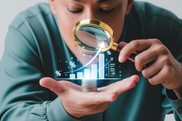 Businessman using a magnifying glass to analyze a growing bar chart on a stack of coins, symbolizing investment research and financial success
