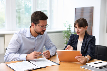 Consultant working with client at table in office. Business meeting