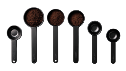 Black measuring cups, various sizes, filled with coffee grounds