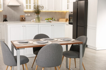 Kitchen interior with dining table, place setting and grey chairs