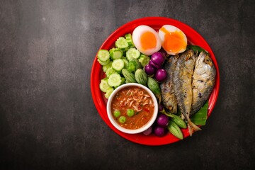 A set of thai cuisine shrimp paste dip with fried mackerel ,fried egg with climbling wattle,soft boiled eggs and set of vegetables