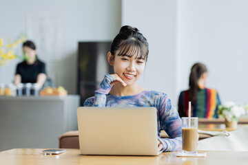 カフェで仕事をするフリーランスの若い女性
