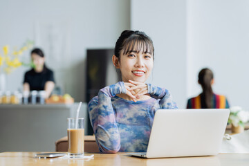 カフェで仕事をするフリーランスの若い女性
