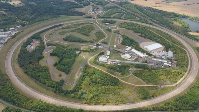 Aerial view of Millbrook Proving Ground, a large vehicle testing facility surrounded by lush greenery and test tracks, Bedford, England, United Kingdom.