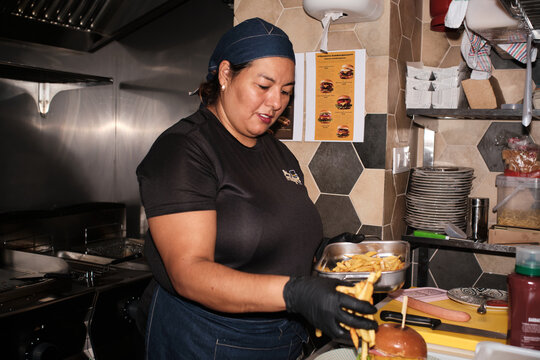 Woman chef preparing burger and french fries
