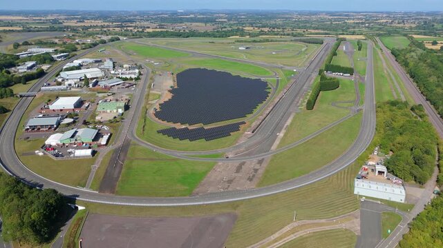Aerial view of the Mira Technology Park with its test tracks and solar panel array surrounded by verdant greenery, Nuneaton, England, United Kingdom.