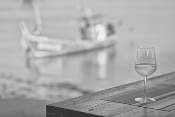 Obraz premium glass of cold white wine on the summer seashore by the water, relaxing by the water, a gentle background of soft color