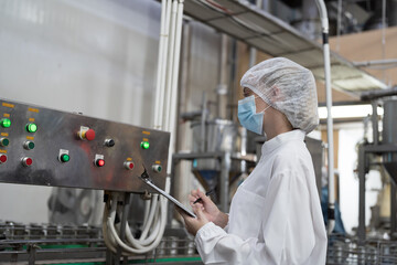 Factory worker working in canned fish factory production line, checking and control conveyor belt. Canned fish factory, seafood manufacturing and processing