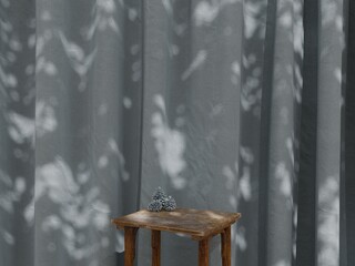 Wooden table with pine cones against slate blue curtain, soft sunlight and shadow background interior mockup
