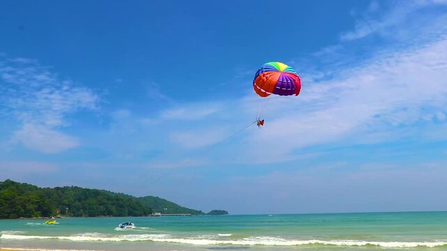 Patong Beach Phuket with turquoise blue water and parasailing Thailand.