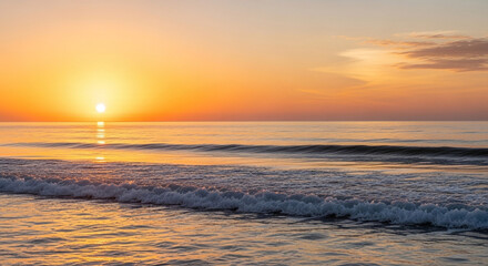 Golden sunrise over the ocean with gentle waves and a clear sky