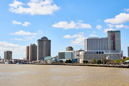 Skyline of downtown New Orleans with modern high-rise buildings viewed from the Mississippi River on a clear sunny day.