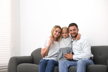 Obraz premium Happy family spending time together on sofa at home. Space for text
