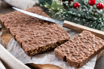 Traditional pieces of delicious Christmas chocolate nougat on wooden table. Copy space