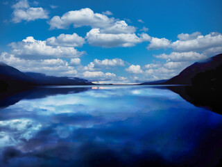 A beautiful blue sky with clouds and a calm lake