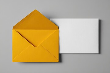 Open mustard-yellow envelope and blank white card on gray background