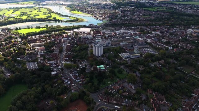 Aerial drone flies over towards Fareham town centre with river in the background, capturing roads, cars, and autumn trees bathed in warm golden sunset light across the scenic English landscape.