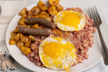 fried eggs  on corn beef hash and home fries