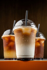 Iced coffee drinks in takeaway cups with straws