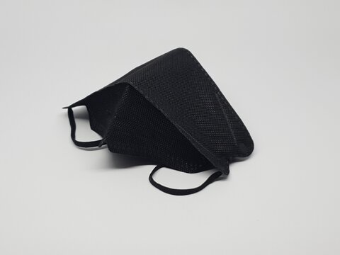 Black reusable cloth face mask isolated on white background, protection against dust and germs