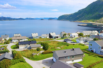 View of the Atlantic Ocean and houses on the shore from Alnes lighthouse, Alnes island, Norway