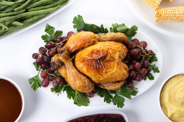 Thanksgiving dinner with turkey,mashed potatoes,ears of corn and green bean casserole on white background