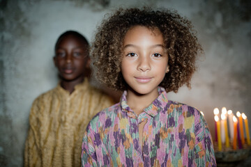 Children listen intently as an elder tells a Kwanzaa story, surrounded by the warm glow of a kinara, showcasing their diverse heritage and expressions of curiosity