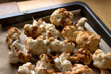 Oven-baked cauliflower florets topped with a flavourful sauce made from olive oil, sweet paprika, garlic, and cumin - perfect for a healthy dinner..