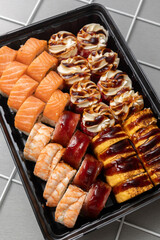 Assorted sushi rolls served on light background, Japanese cuisine, restaurant menu concept.