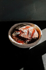 Freshly baked sourdough bread resting in a basket with soft light illuminating its crust