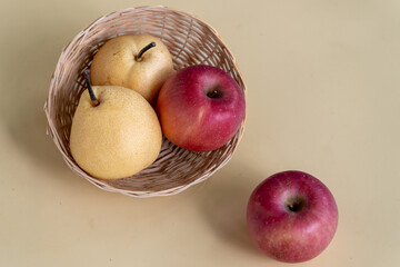 Fresh pears and apples arranged in a basket