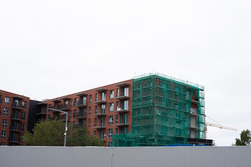Multi-storey building under construction with facade works.