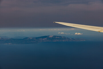 Beautiful view of the airplane wing and the island in the sea.