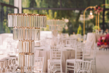 Elegant table setting with glass decor in a bright banquet hall during a festive celebration in the afternoon sunlight