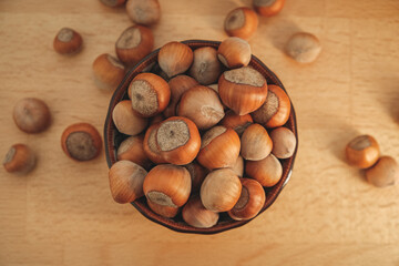 Freshly harvested hazelnuts in a wooden bowl on a rustic table