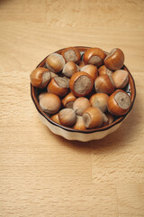 Nuts piled high in a charming bowl on a wooden table for a cozy snack