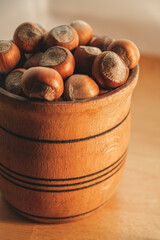 Freshly harvested hazelnuts in a rustic wooden bowl on a wooden table