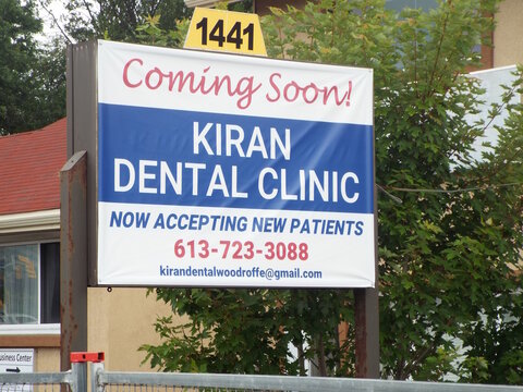 Nepean, ON, Canada, June 19, 2025:  A temporary banner sign for  "KIRAN DENTAL CLINIC"  news  business coming to the location at 1441 Woodroffe Ave.
