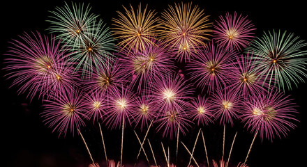 Fototapeta premium Stunning fireworks display with vibrant bursts of pink, gold, and green lighting up the dark night sky for a festive Diwali or New Year's celebration.