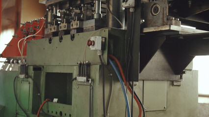 Industrial manufacturing equipment in a modern factory, close up of mechanical components, hydraulic lines, electrical cables and metal parts highlighting precision automation processes