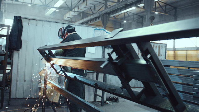 Skilled industrial worker wearing protective gear while welding metal components, creating sparks and showcasing manufacturing processes and precision in a factory environment