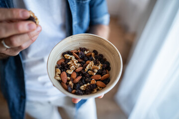 Man holding bowl of healthy trail mix snack © Migma_Agency