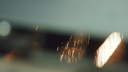 Golden light streaks and shimmering bokeh patterns generate an abstract illumination against a soft, blurred background, evoking concepts of energy, celebration, and magic