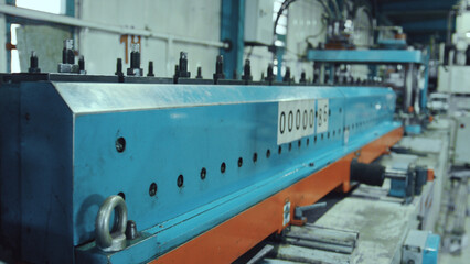 Fototapeta premium Metalworking machine performing industrial production process, shaping steel sheets in a busy factory environment, symbolizing automation and precision engineering