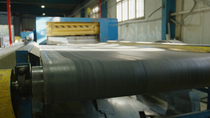 Naklejka premium Conveyor belt system moving metal sheets along an active production line in a manufacturing plant, showcasing industrial automation and a continuous workflow process