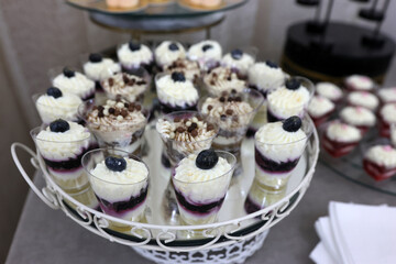 A tray of cakes and pastries on a buffet table.