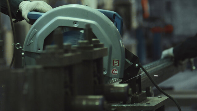 Worker using an industrial chop saw to cut a long metal profile in a manufacturing plant, highlighting the meticulous process of metalworking and fabrication industry - Powered by Adobe