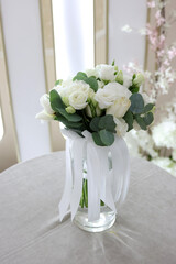 A beautiful bouquet of white roses in a vase on the table.