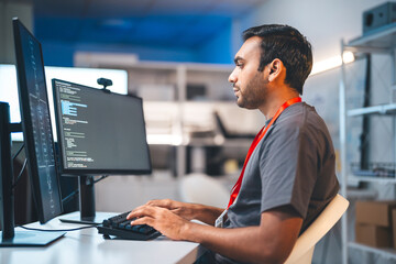 Obraz na płótnie Canvas Indian programmer coding typing keyboard in modern office software developer programming IT technology career